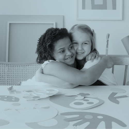 two little girls hugging and smiling